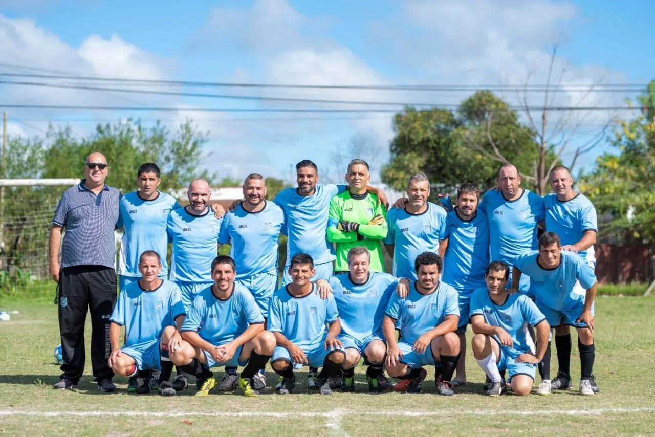 Otro plantel del club posando en la cancha junto al cuerpo técnico